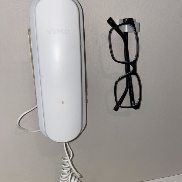 glasses hanging next to phone
